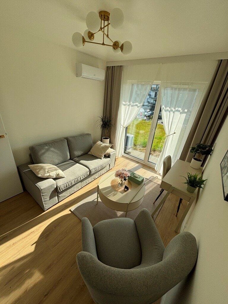 asny i przytulny gabinet psychologiczny Portalu PsychologNaFali w Gdańsku przy ulicy Pastelowej, wyposażony w szarą sofę, nowoczesny fotel oraz biurko do konsultacji stacjonarnych dla Klientów.
